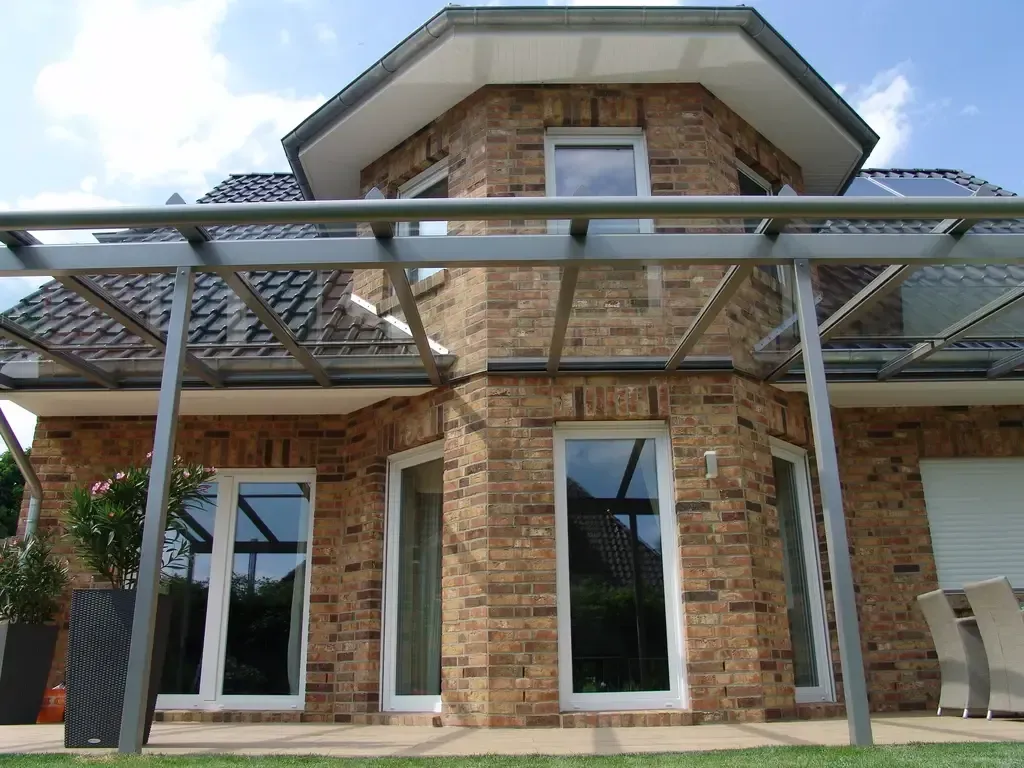 Ein großes Backsteinhaus mit einer Pergola darauf