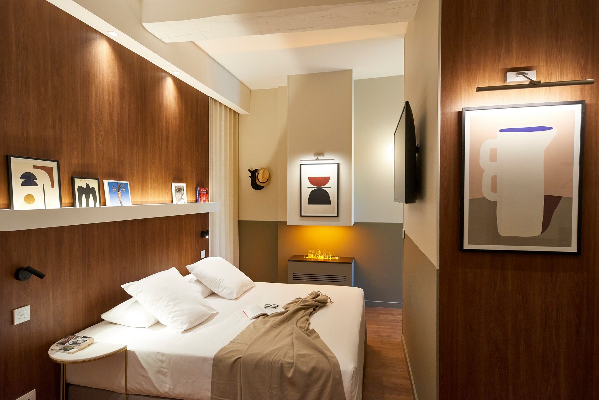 Chambre avec lambris, œuvres d'art, lit et télévision.