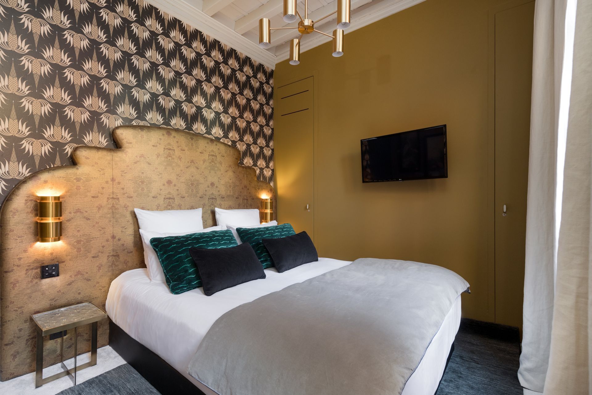 Chambre avec lambris, œuvres d'art, lit et télévision.