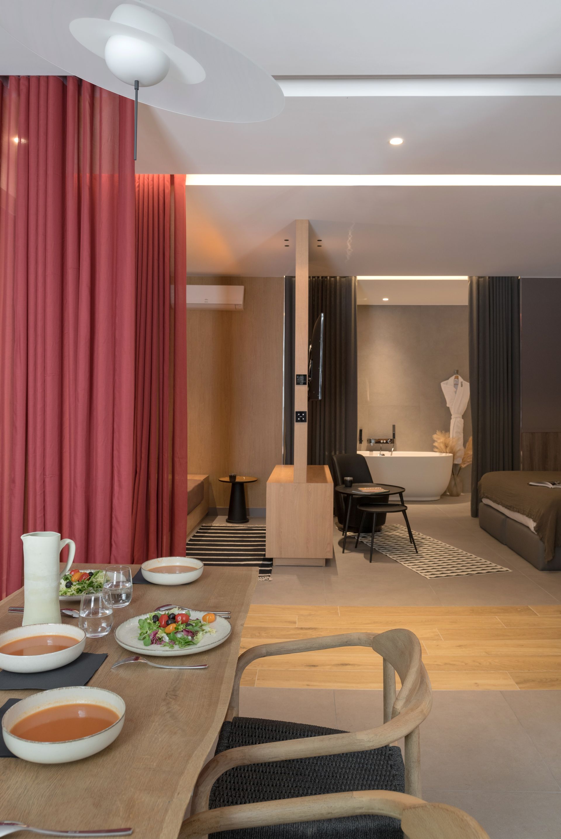 Intérieur de spa avec baignoire, table et chaise, et rideaux.