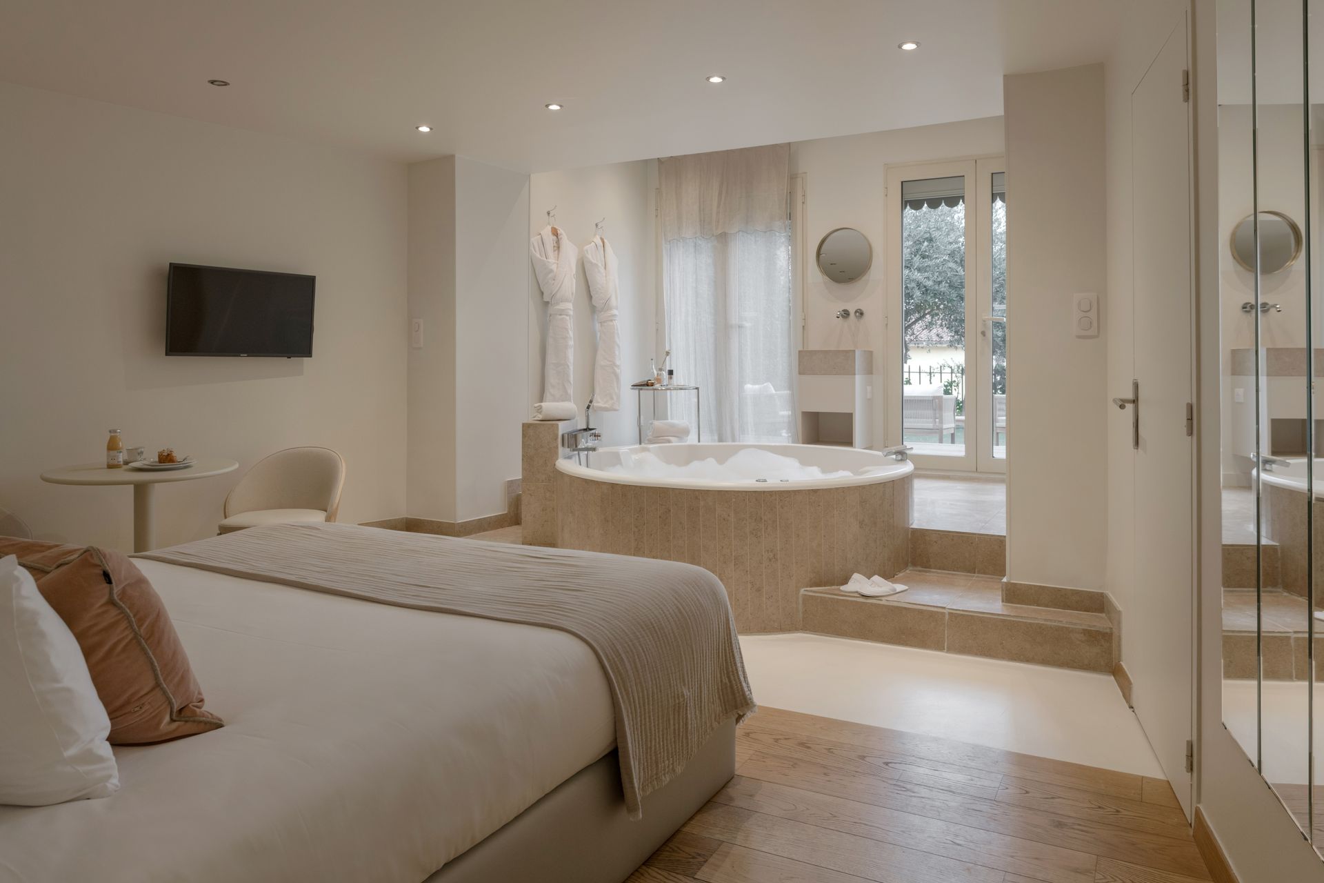Intérieur de spa avec baignoire, table et chaise, et rideaux.