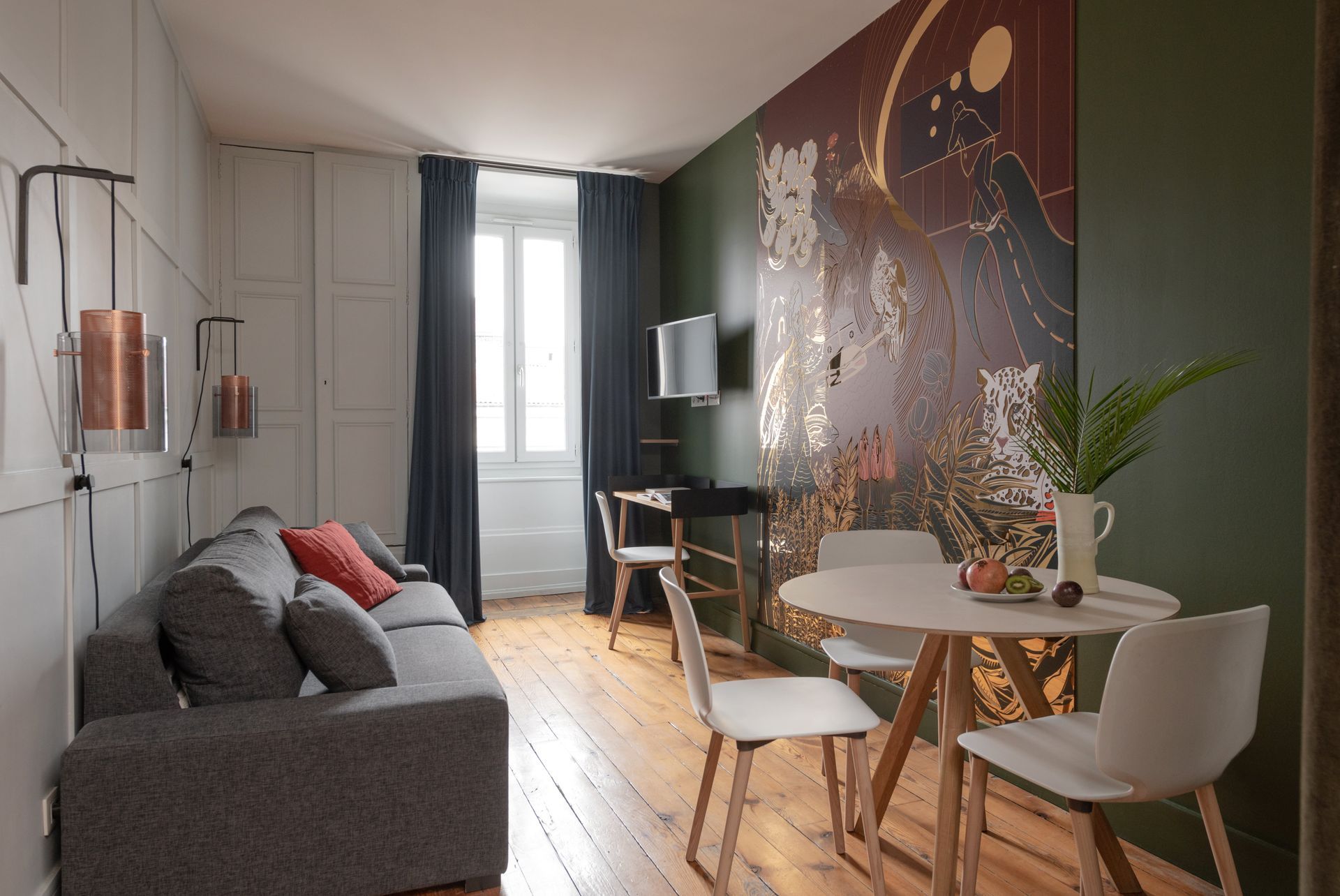Chambre avec lambris, œuvres d'art, lit et télévision.