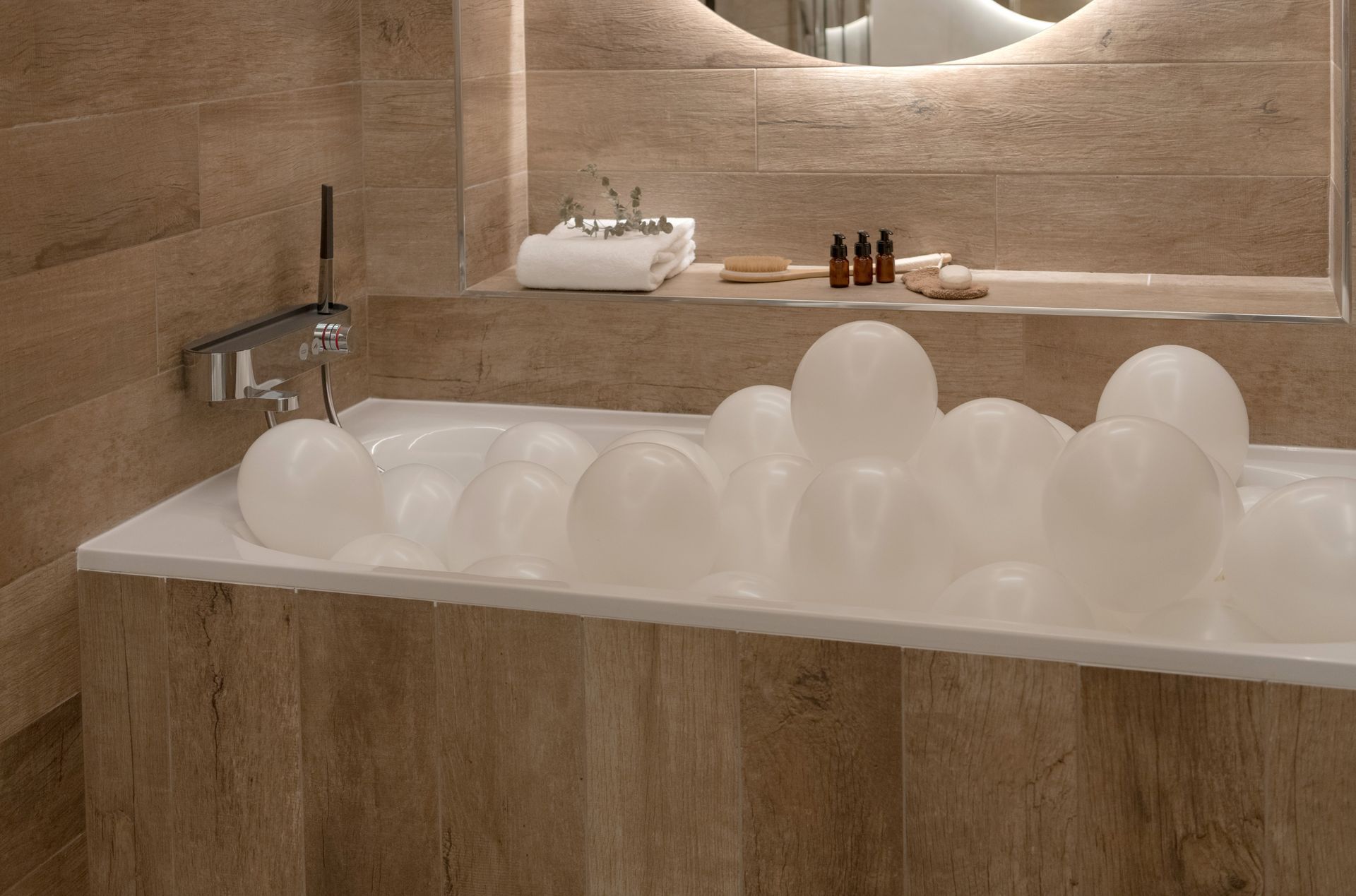 Salle de bains luxueuse avec baignoire îlot, chaise longue rouge et œuvres d'art sur les murs roses.