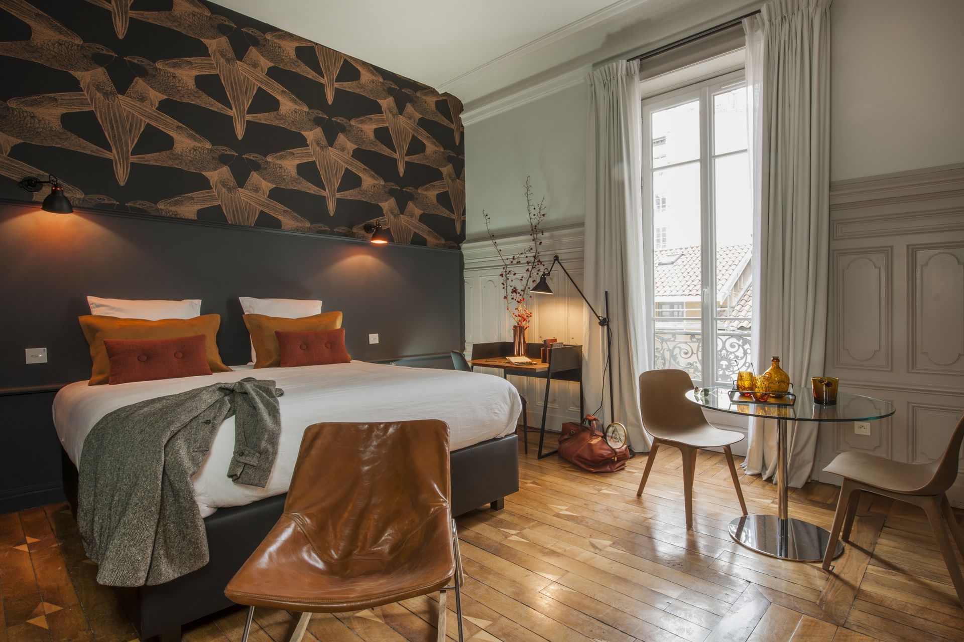 Salle de bains luxueuse avec baignoire îlot, chaise longue rouge et œuvres d'art sur les murs roses.