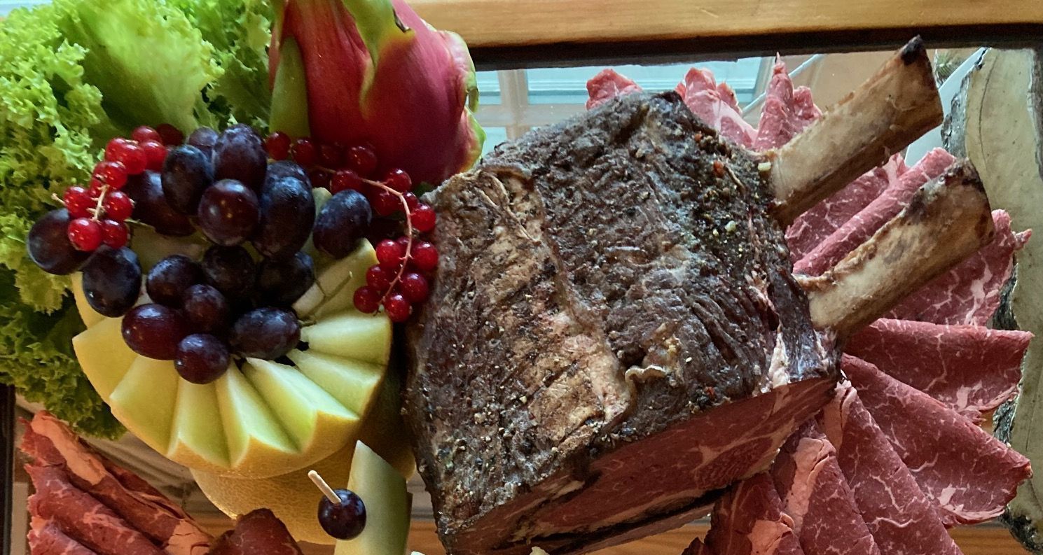 Ein Tablett mit Fleisch, Käse, Obst und Gemüse auf einem Tisch.