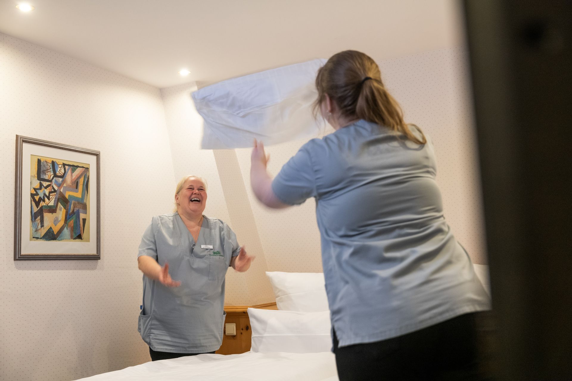 Eine Frau macht in einem Hotelzimmer ein Bett.