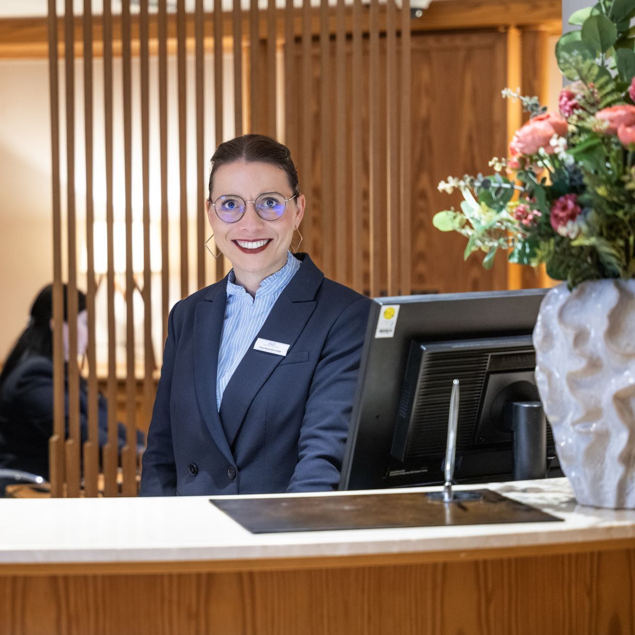 Eine Frau sitzt an einem langen Tisch in einem Restaurant.