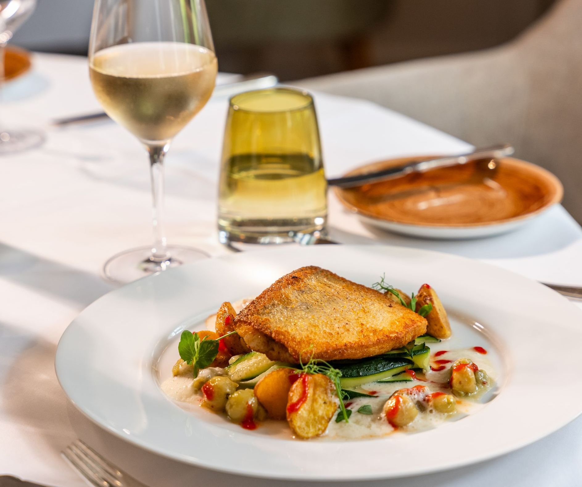 Ein Teller mit Essen und ein Glas Wein auf einem Tisch