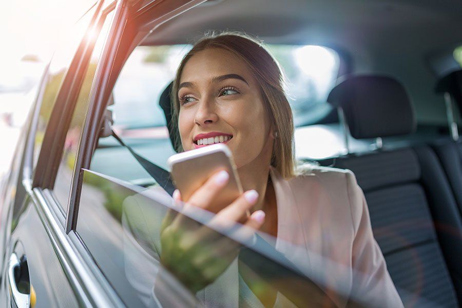 Femme à l'arrière d'une voiture au téléphone