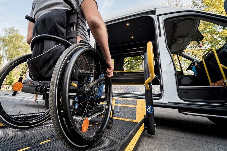 Une personne en situation de handicap en train de monter dans un véhicule