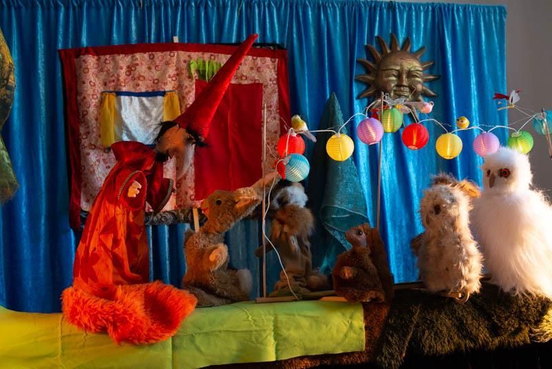 Eine Gruppe ausgestopfter Tiere steht auf einer Bühne mit einem blauen Vorhang dahinter