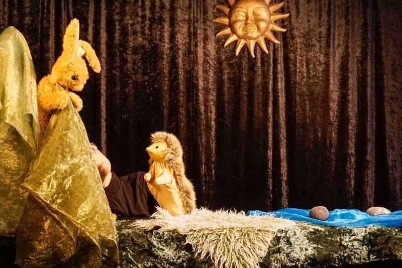 Eine Person hält ein ausgestopftes Kaninchen und einen ausgestopften Igel