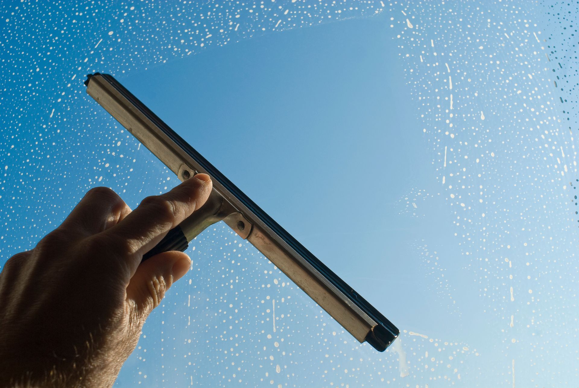 Main qui tient une brosse pour vitre
