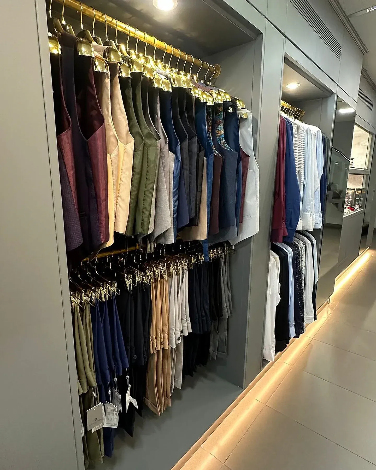 Una tienda llena de ropa colgada en percheros.