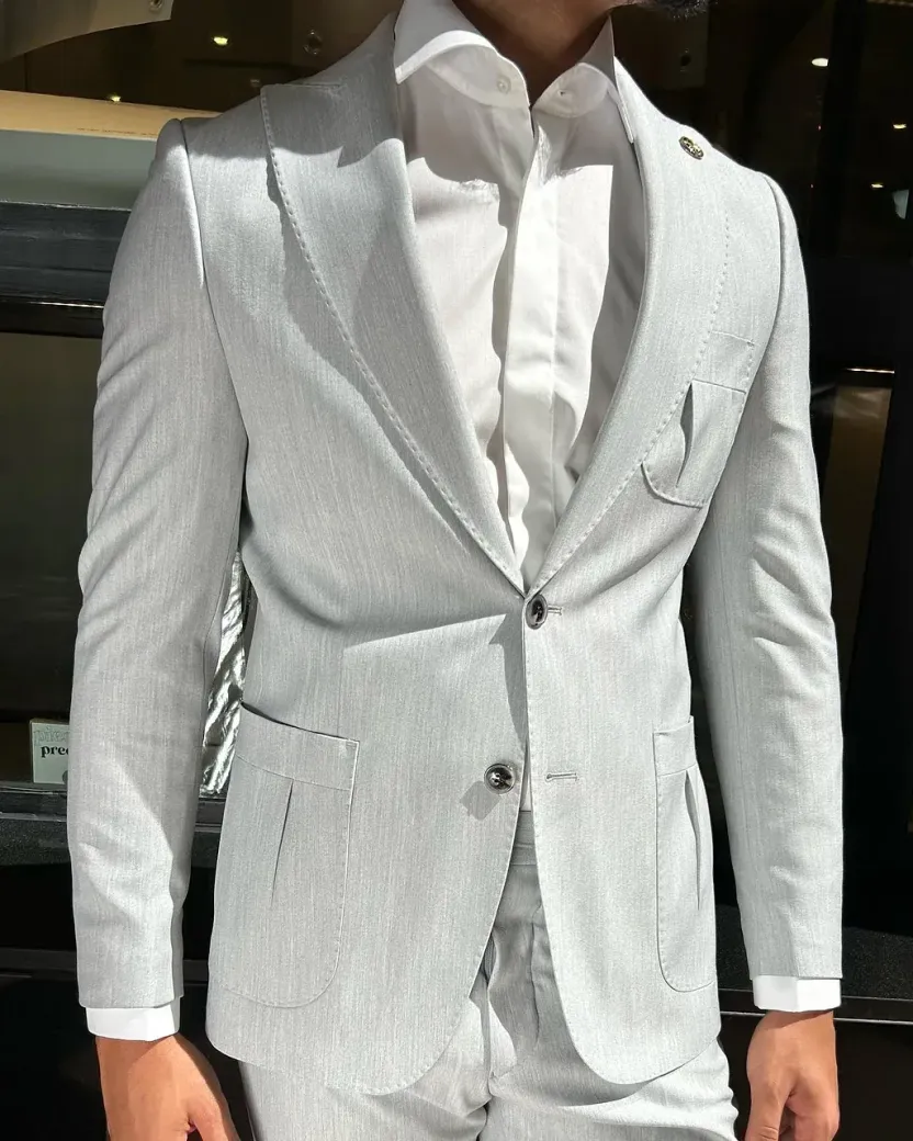 Un hombre vestido con un traje blanco y una camisa blanca