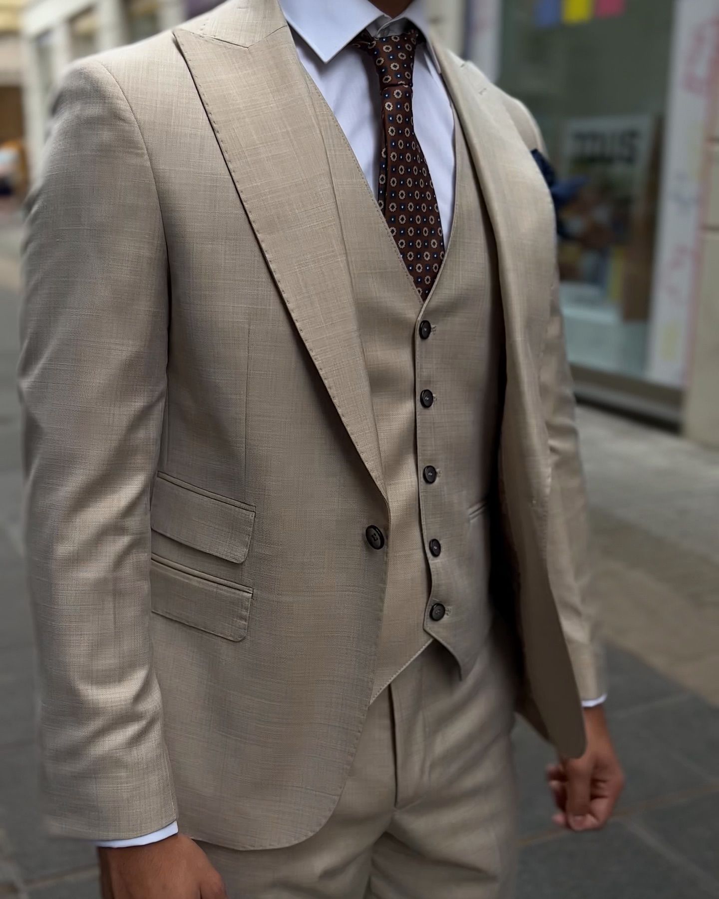 Un hombre lleva un traje color canela y corbata.