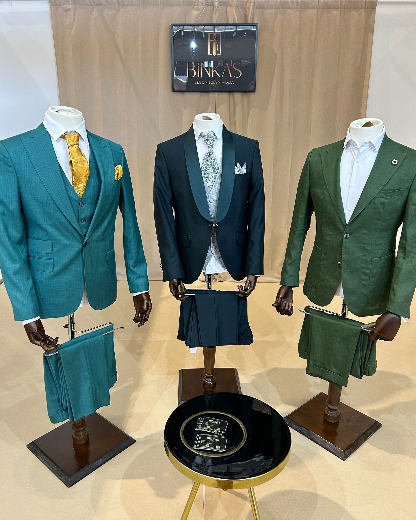 Tres maniquíes vestidos con trajes verdes y corbatas están parados uno al lado del otro.