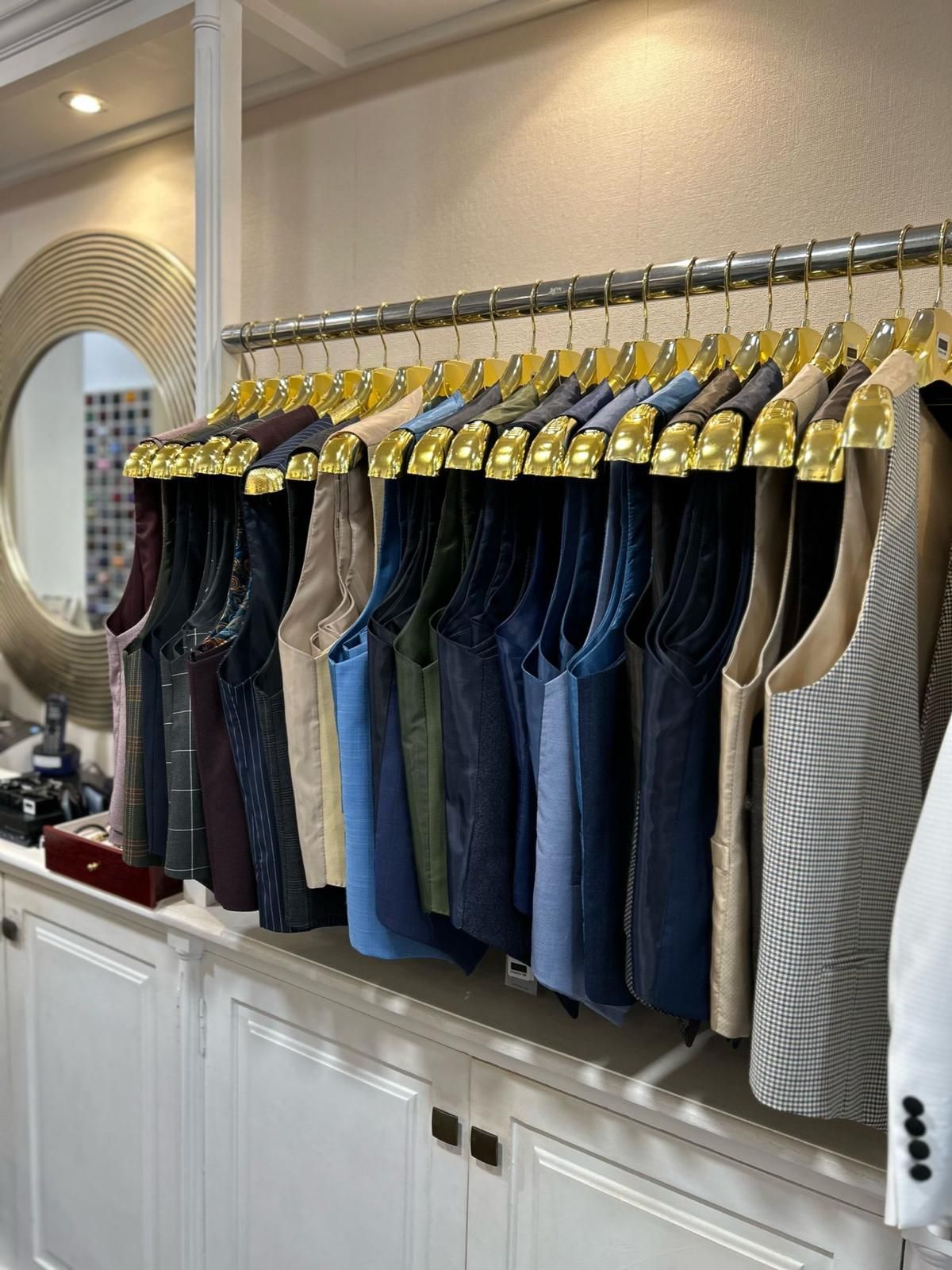Una fila de chalecos están colgados en un estante en una tienda.