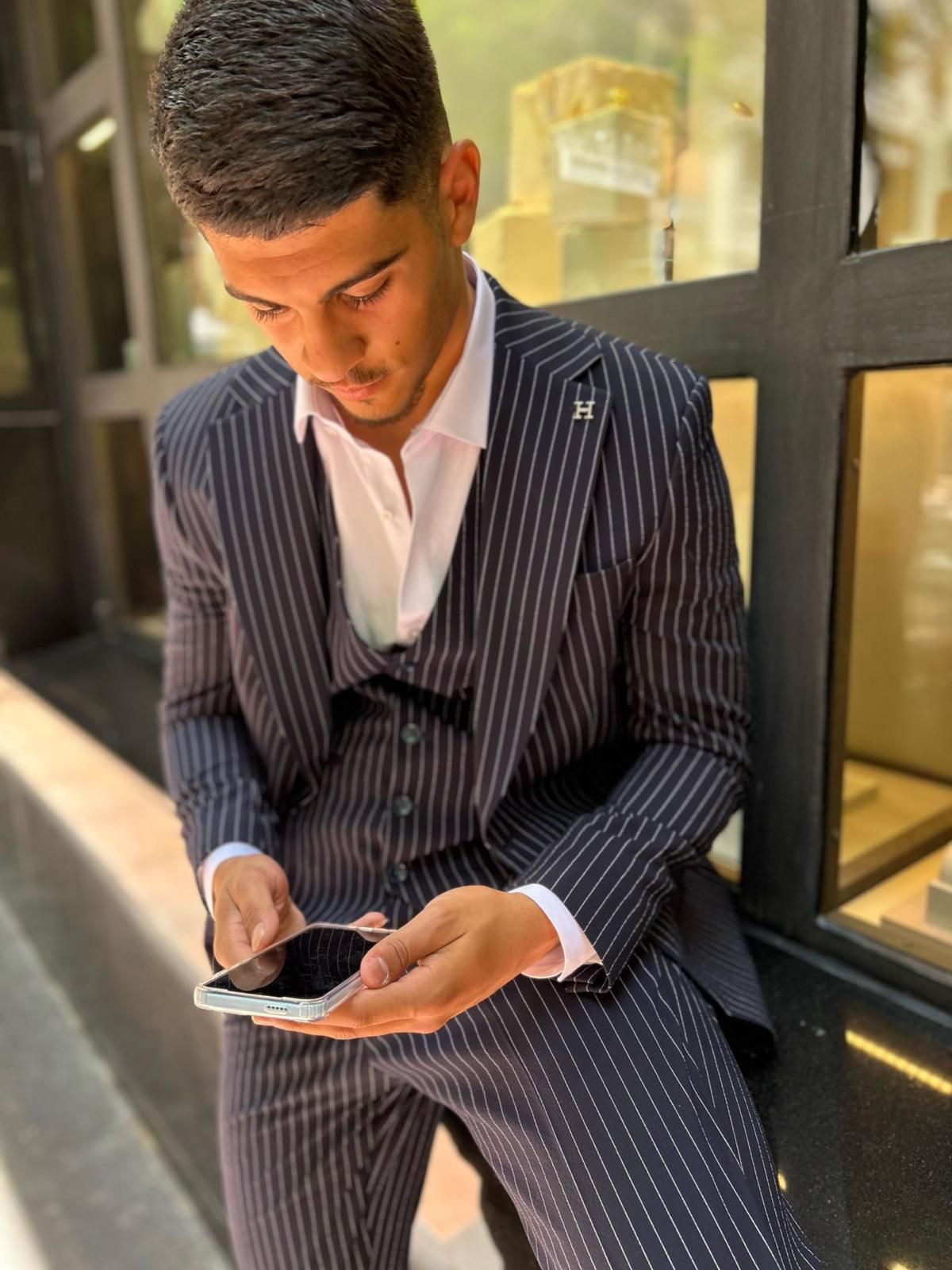 Un hombre con traje está mirando su teléfono celular.