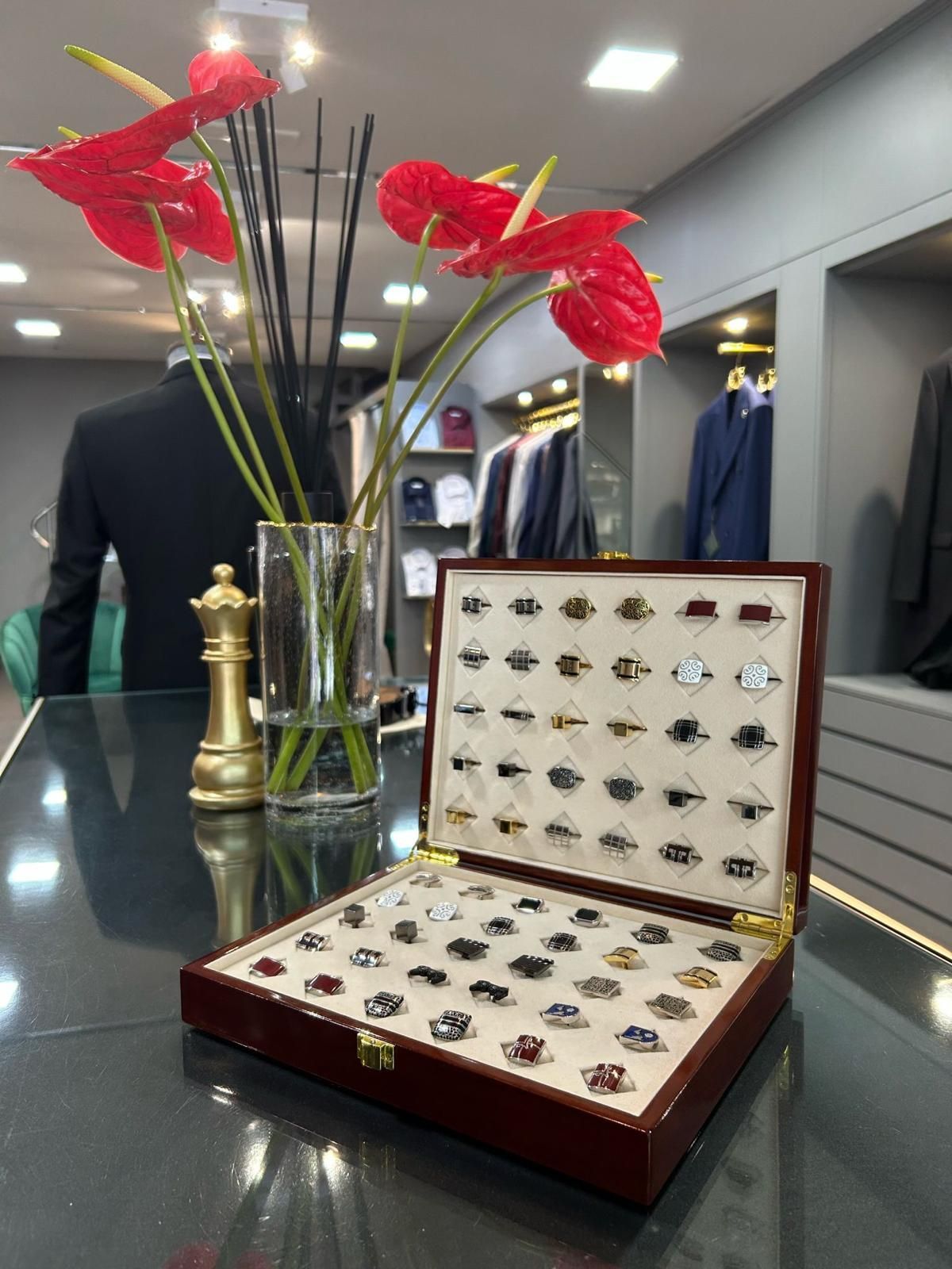 Una caja de gemelos está sobre una mesa al lado de un jarrón con flores.