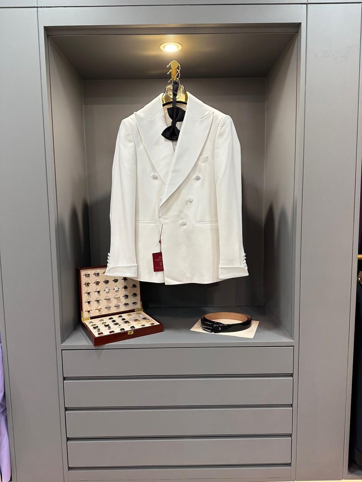 Una chaqueta de esmoquin blanca está colgada en un armario.
