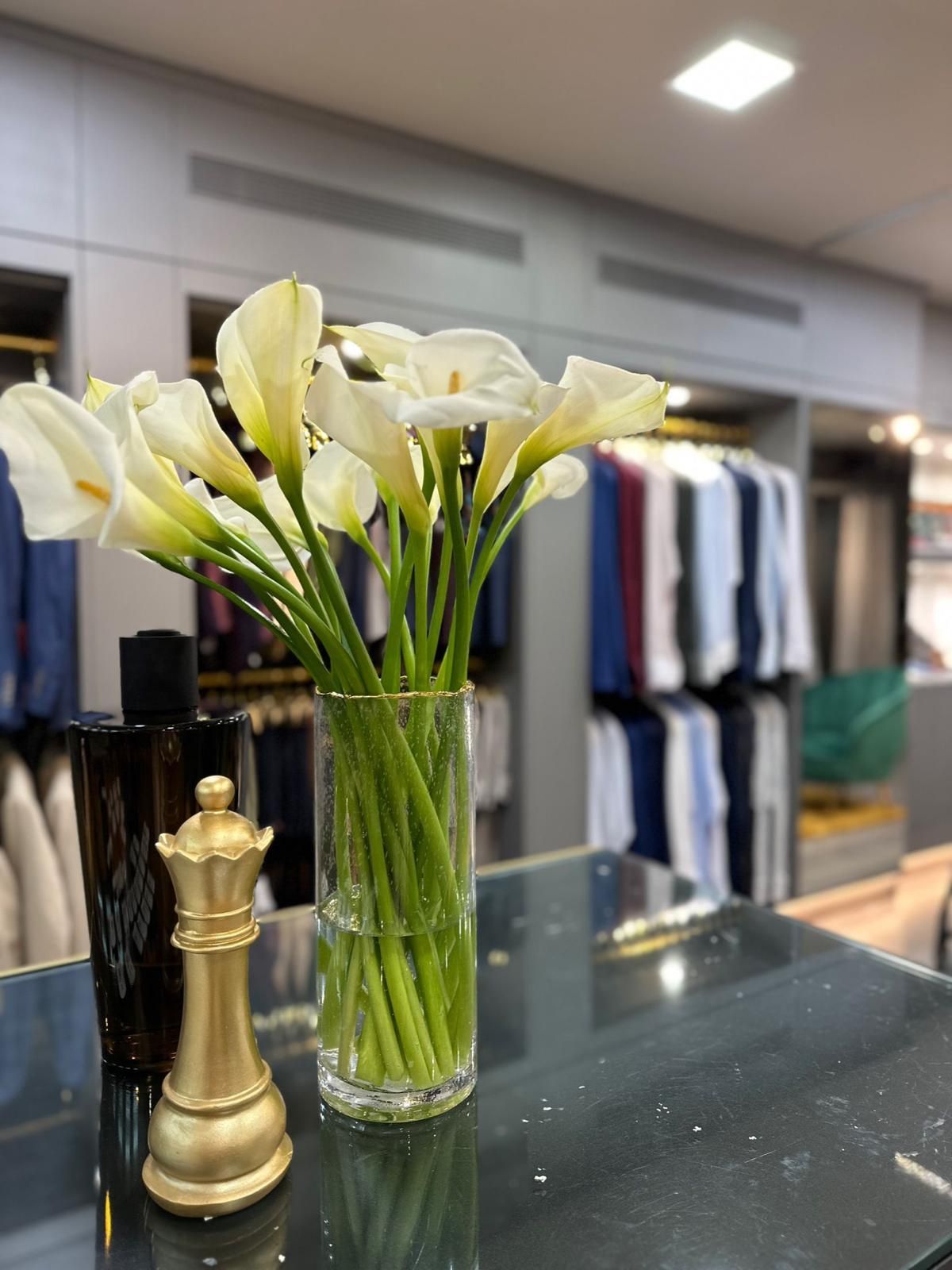 Un jarrón de flores está sobre una mesa al lado de una pieza de ajedrez.