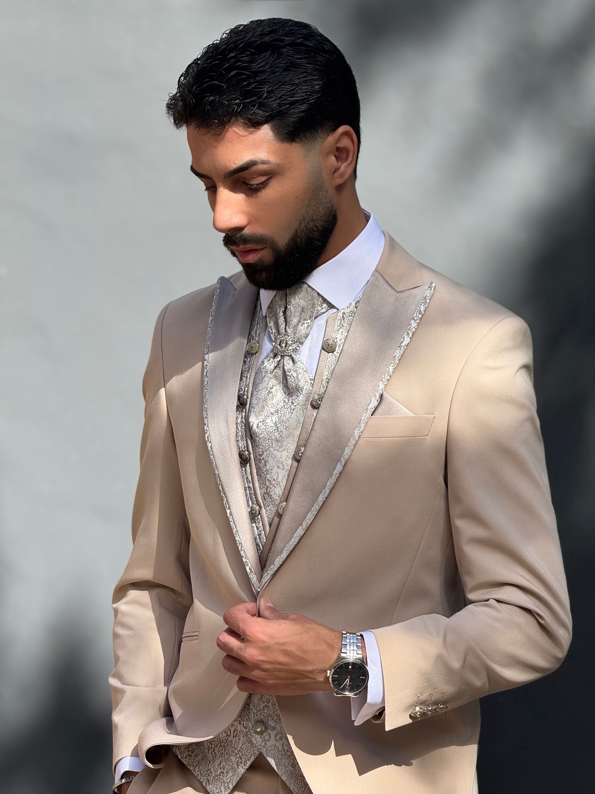 Un hombre lleva un traje color canela y corbata.