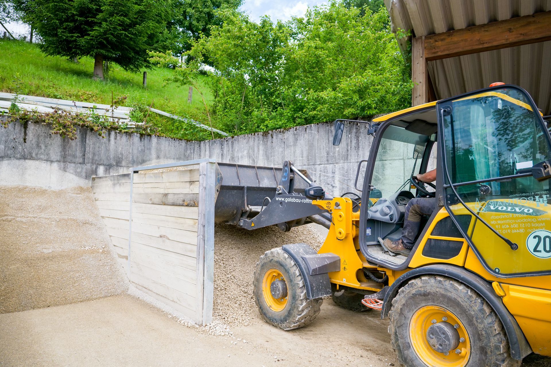 Ein gelber Bagger, der Erde wegschaufelt.