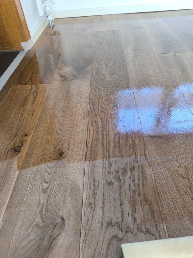 Holzboden mit glänzender, reflektierender Oberfläche.