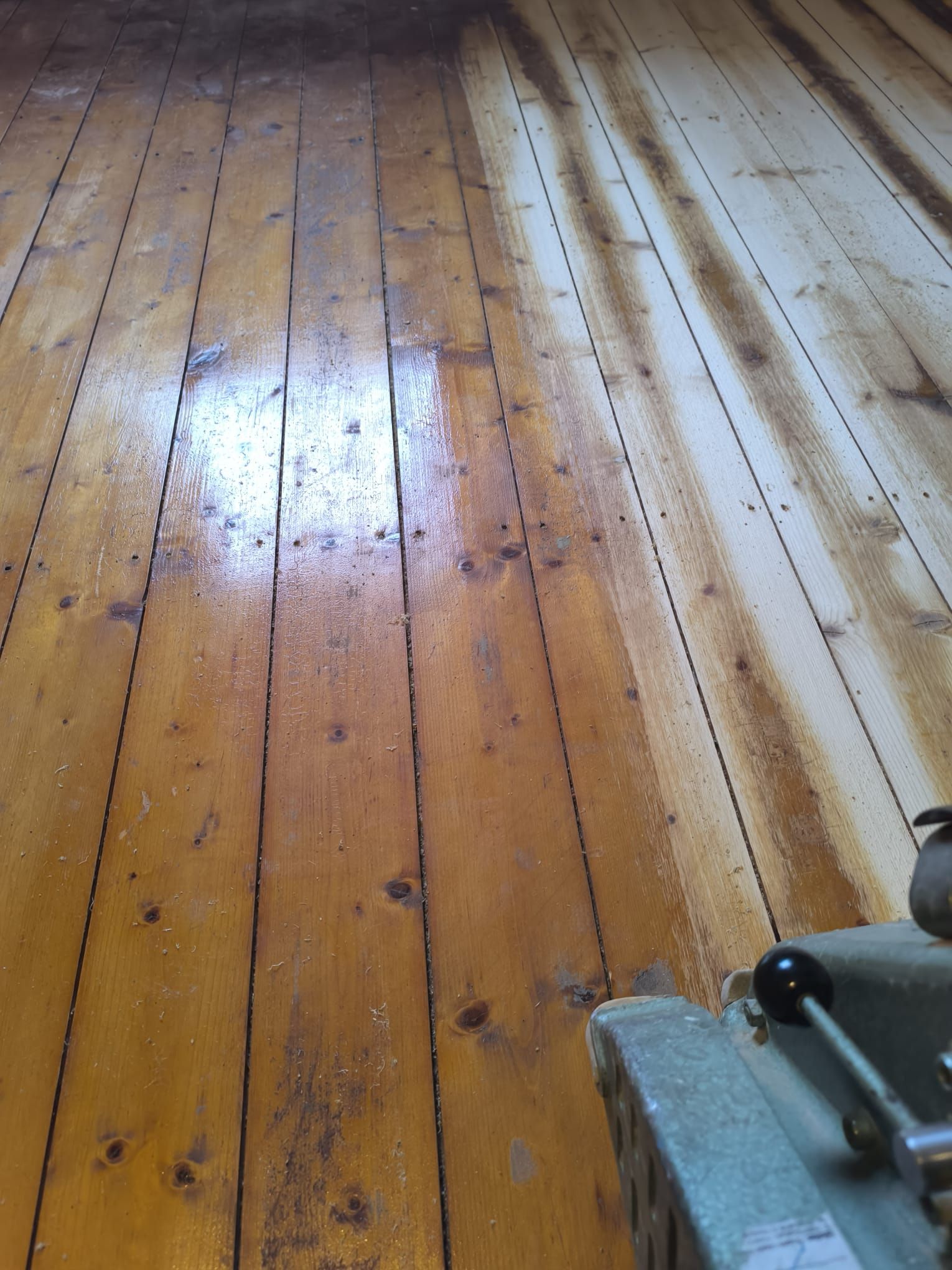 Ein Holzboden wird mit einer Maschine geschliffen