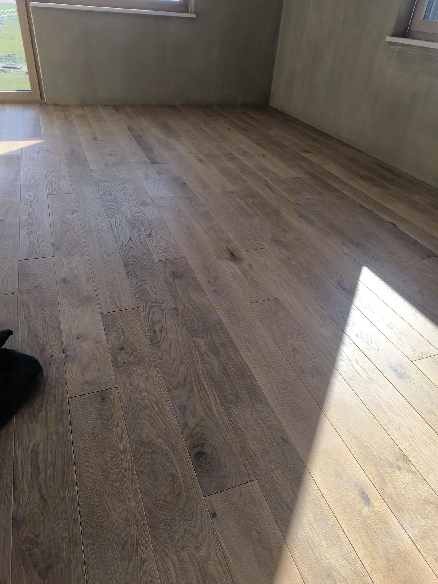 Ein Raum mit Holzboden und Fenster.