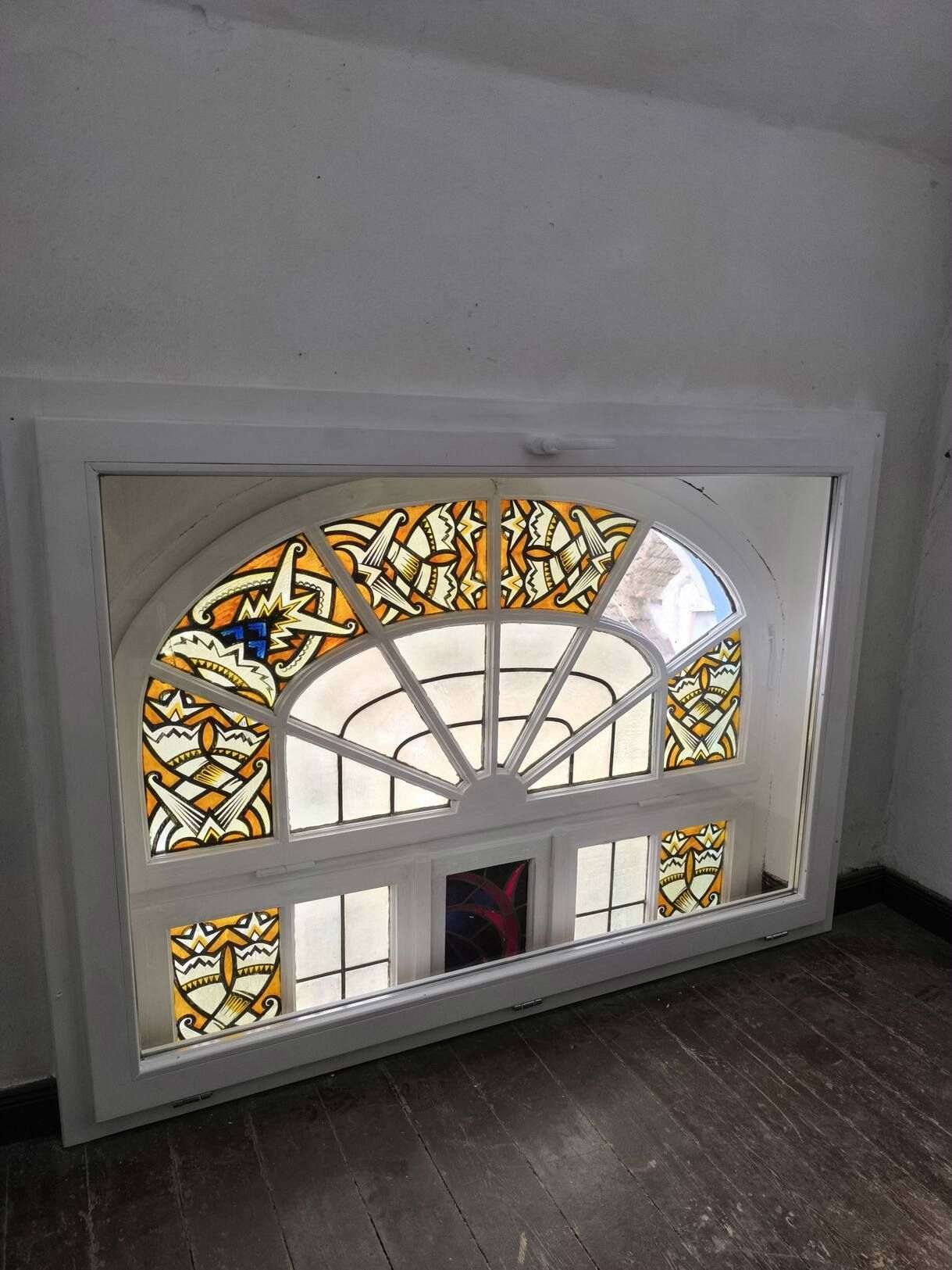 In der Ecke eines Raumes befindet sich ein Buntglasfenster.