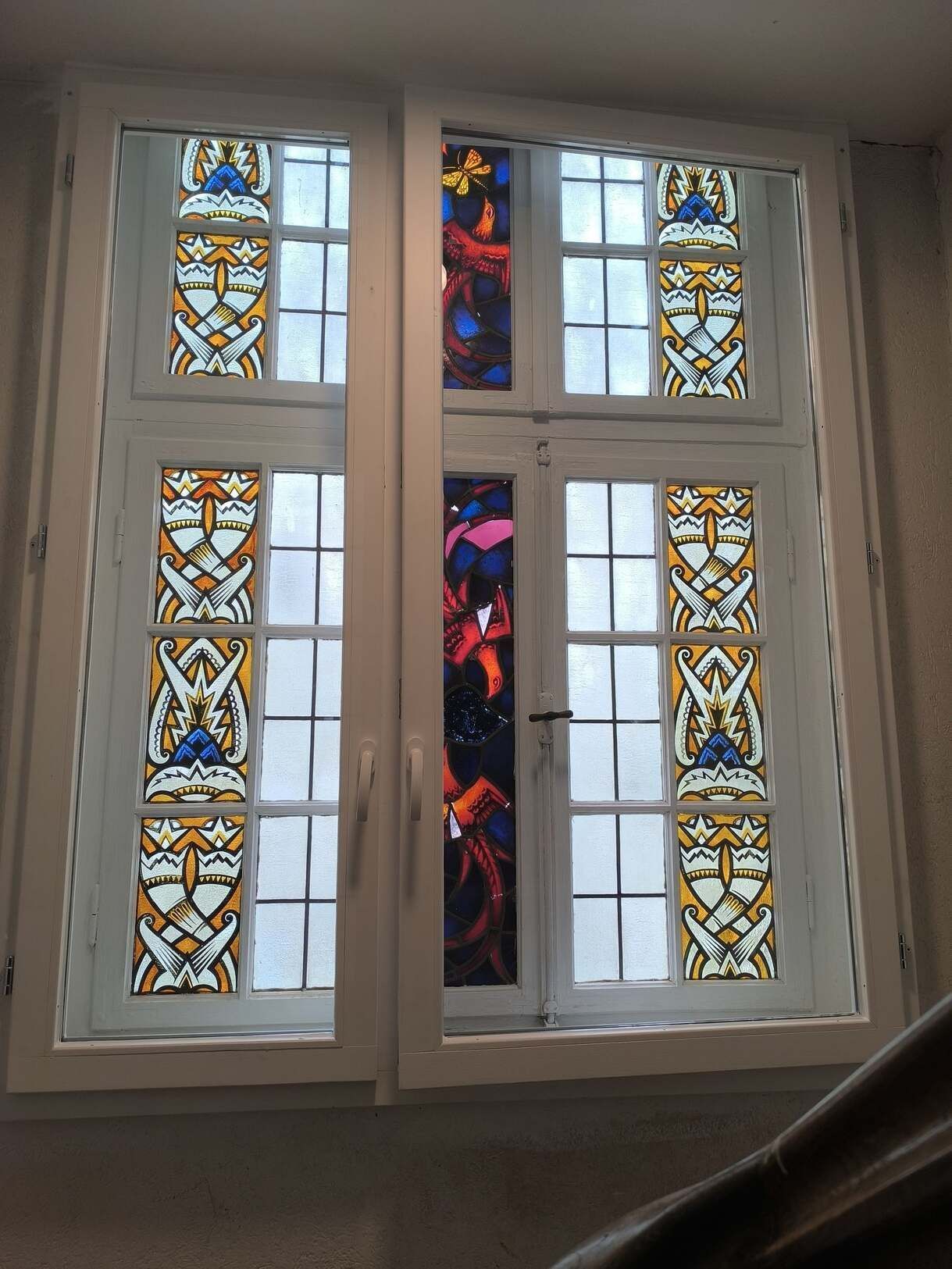 Ein Buntglasfenster mit einer Treppe im Hintergrund