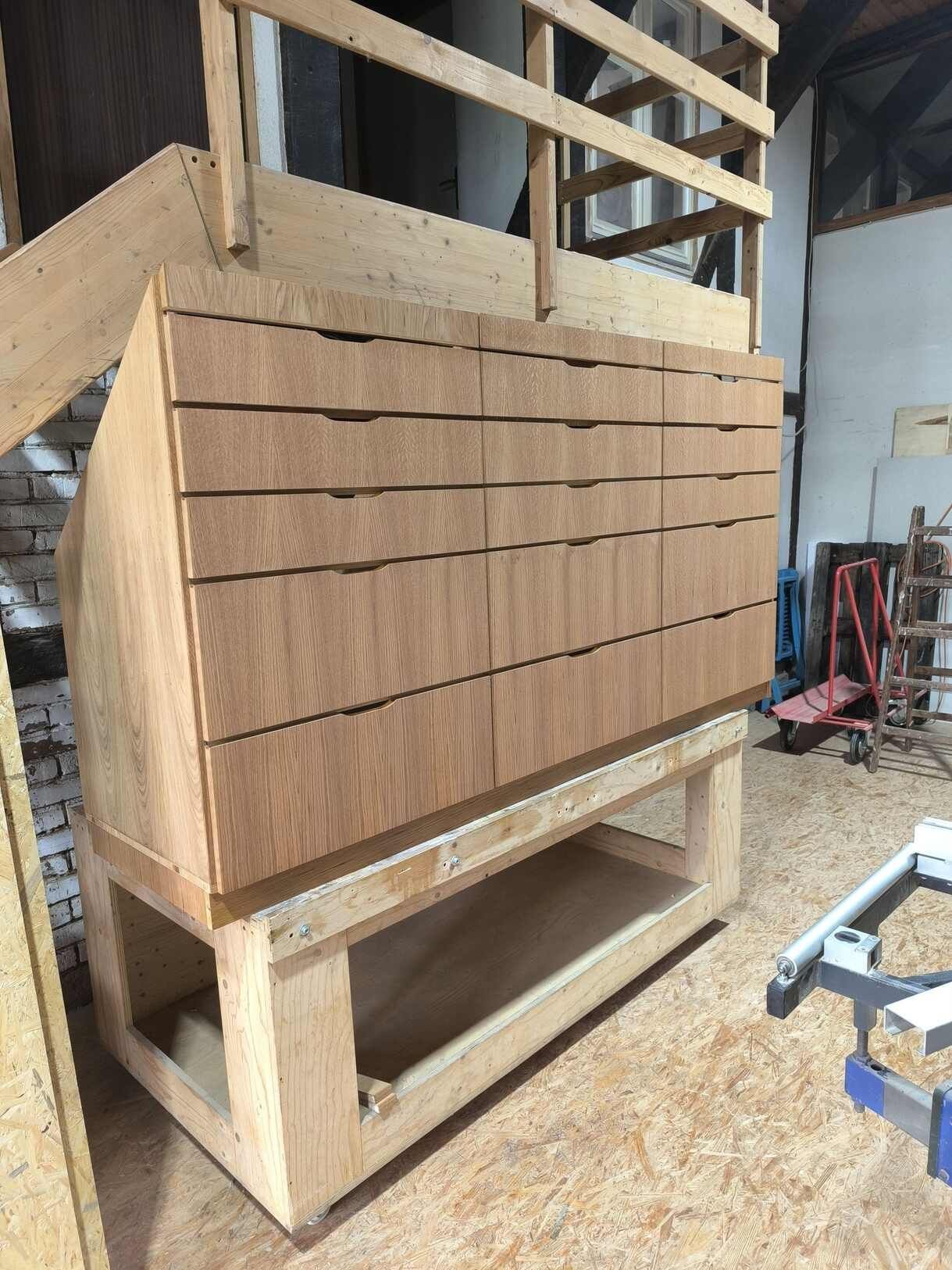 In einer Werkstatt wird eine Kommode aus Holz mit Schubladen gebaut.