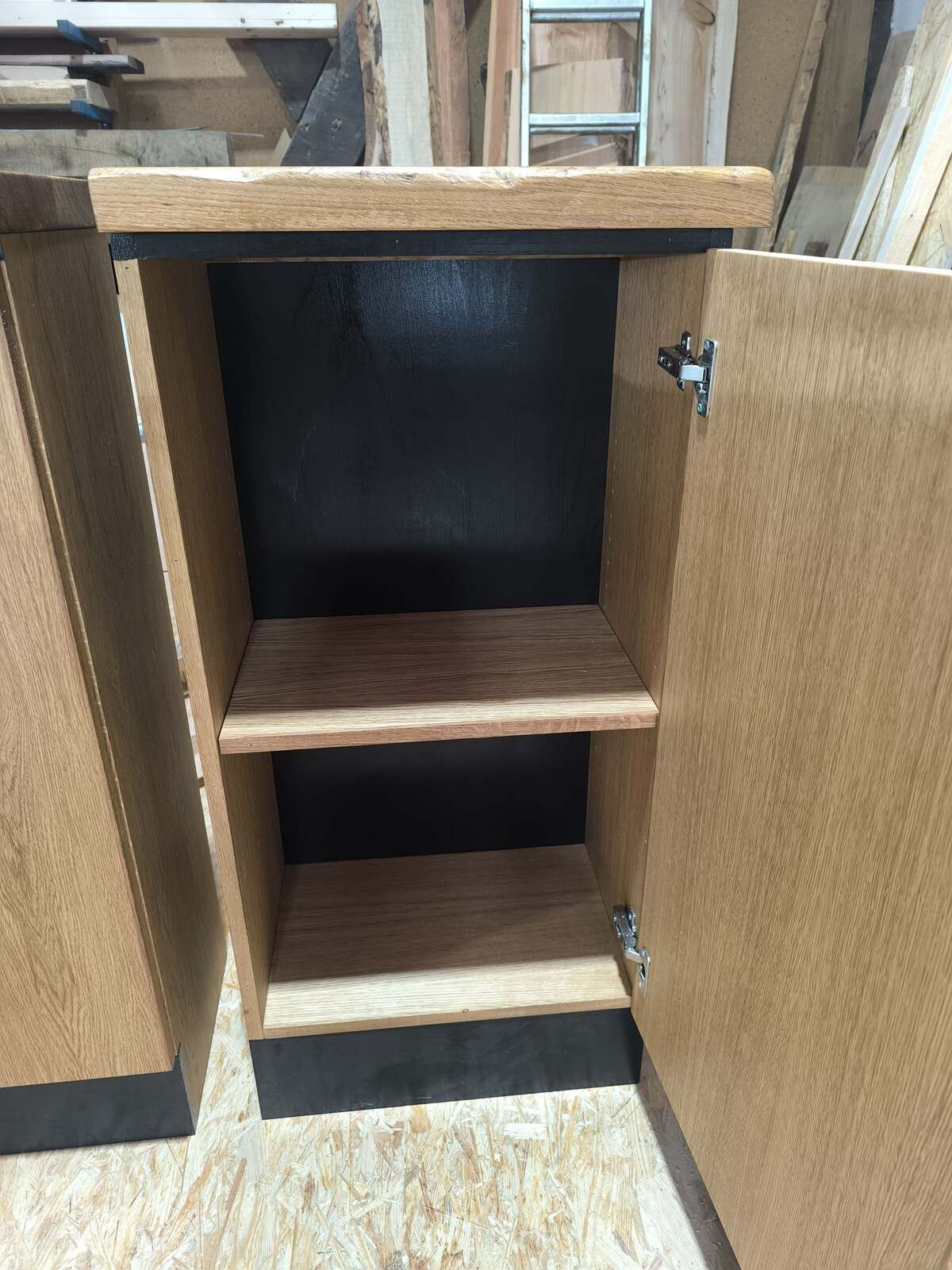 Ein Holzschrank mit offener Tür und zwei Einlegeböden.