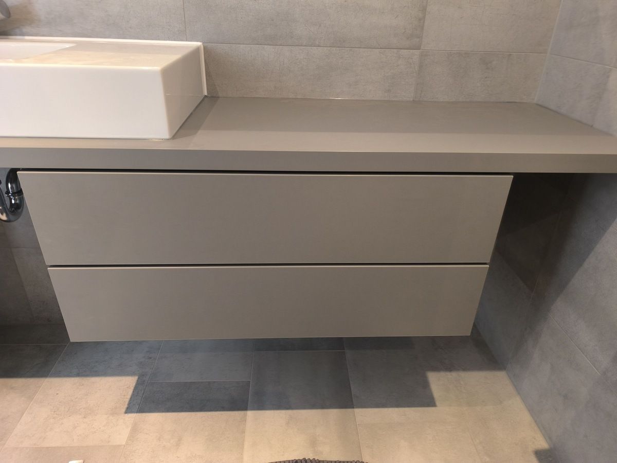 Ein Badezimmer mit einem Waschbecken und einer Schublade darunter.