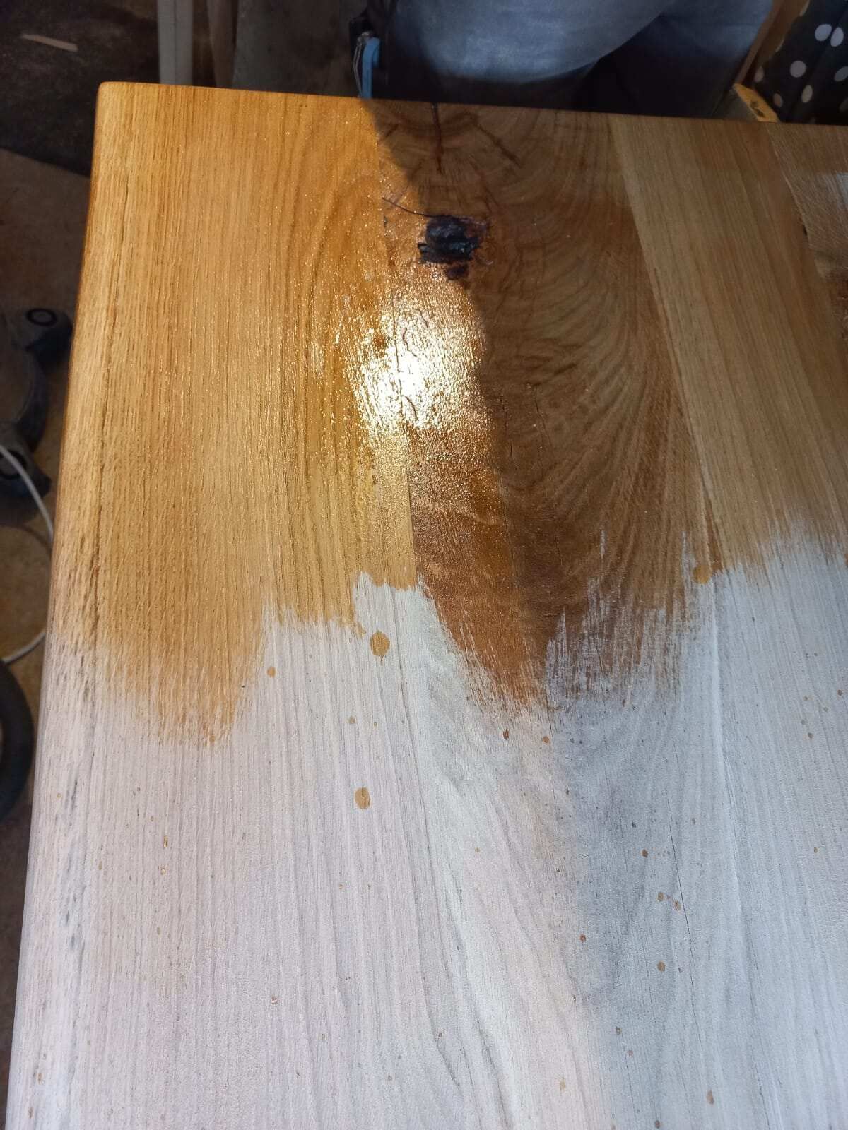 Eine Nahaufnahme eines Holztisches mit einem Fleck darauf.