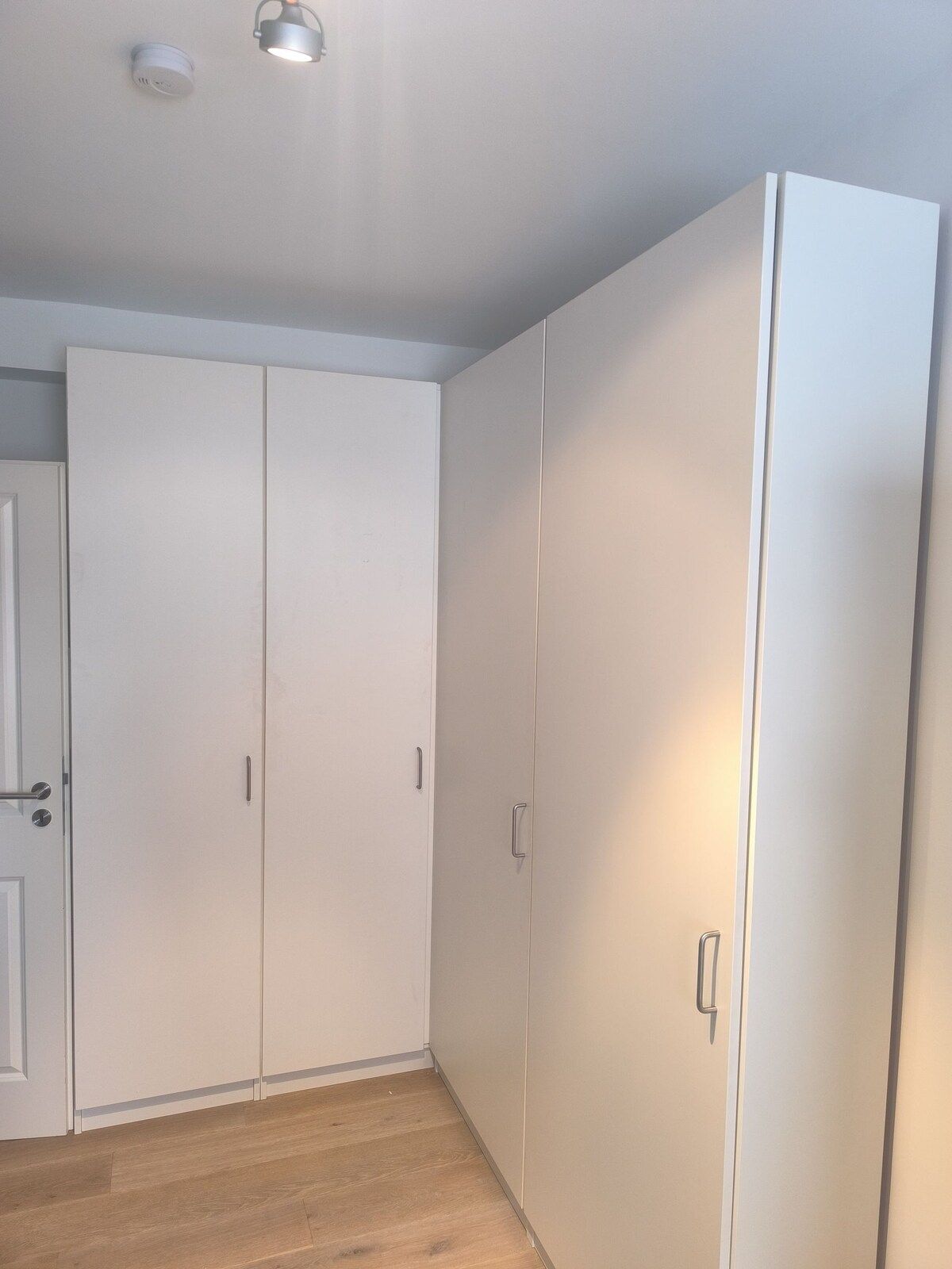 Ein Raum mit vielen weißen Schränken und einer Tür.