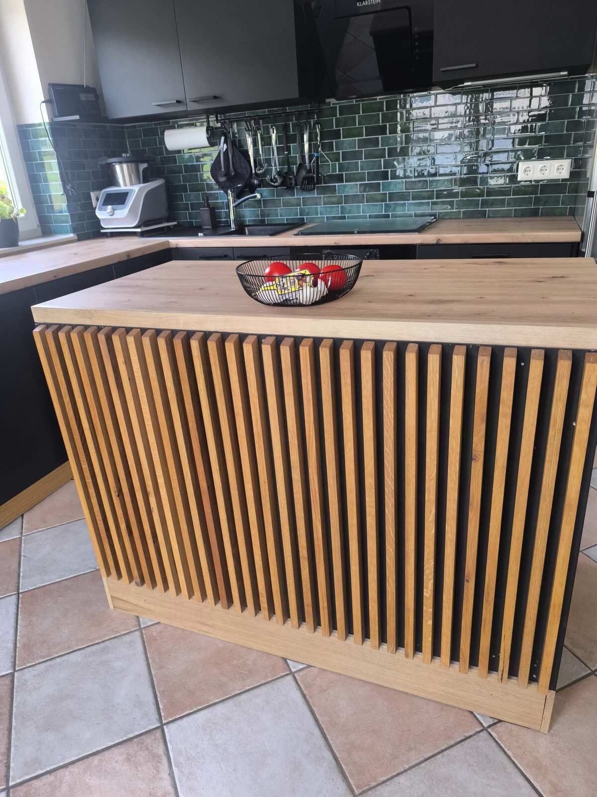 Eine Küche mit einer Holzinsel und einer Schüssel mit Essen darauf.