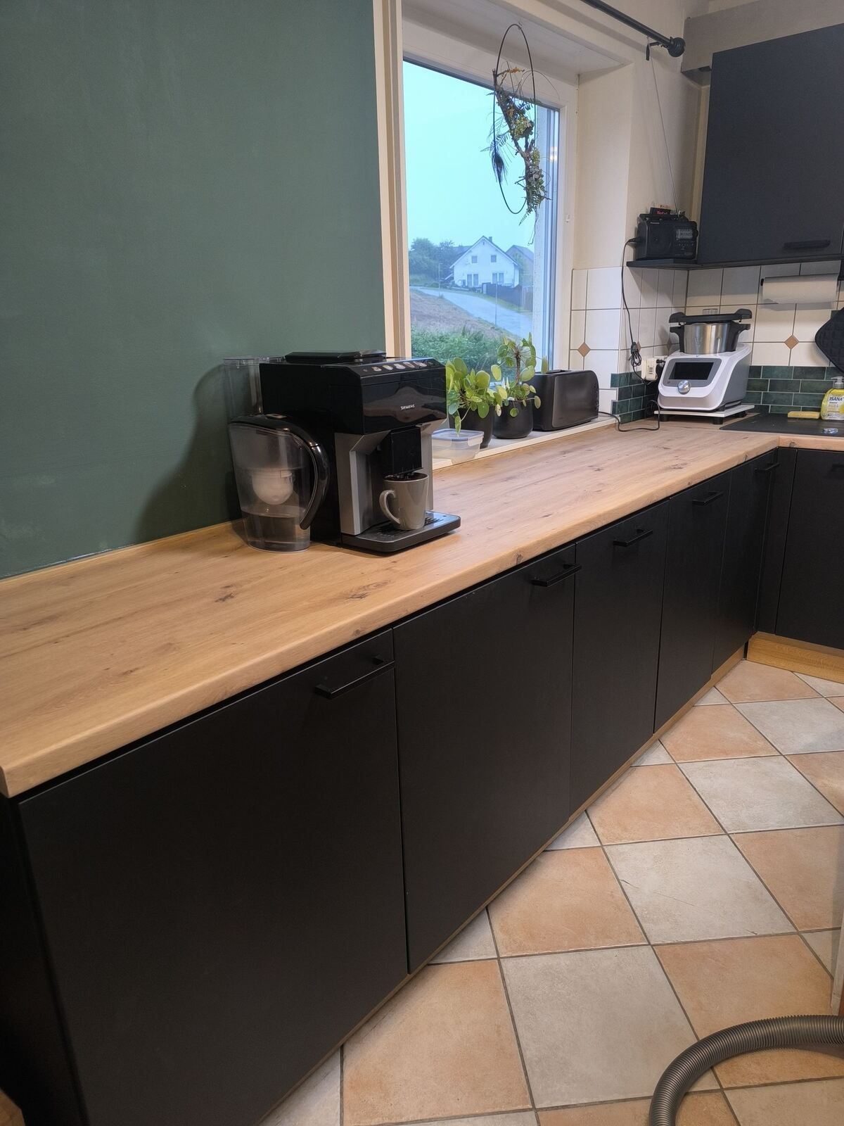 Eine Küche mit schwarzen Schränken und einer Holzarbeitsplatte