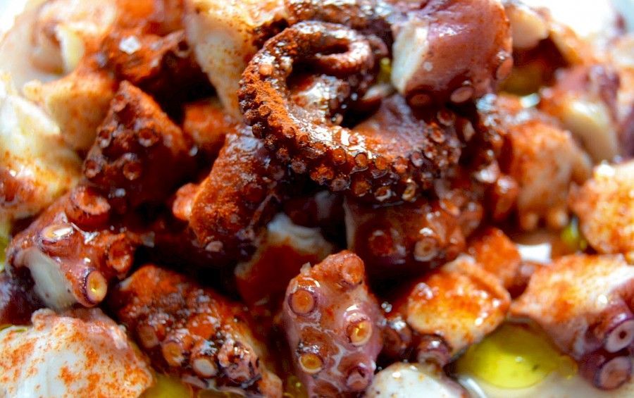 Plato de pulpo picado y aliñado con pimentón, servido con aceite de oliva.