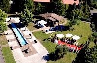 Lugar al aire libre con una larga piscina reflectante, alfombra roja y asientos dispuestos para un evento.