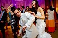 Novia y novio bailando en la recepción de la boda; la novia sonríe, el novio hace una mueca tonta, fiesta de fondo.