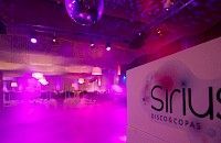 Interior de discoteca vacío con iluminación violeta, bola de discoteca y el logo de