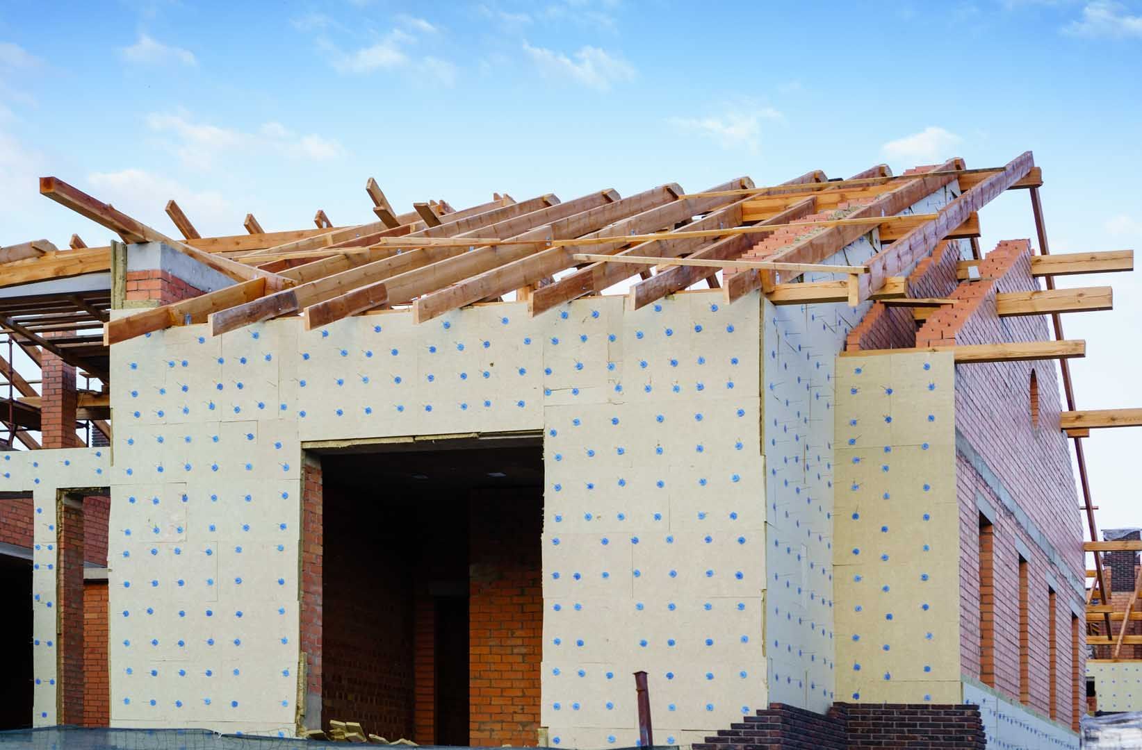 Des plaques isolantes autour d'une maison en construction