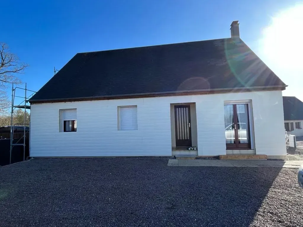 Une maison blanche avec un toit noir