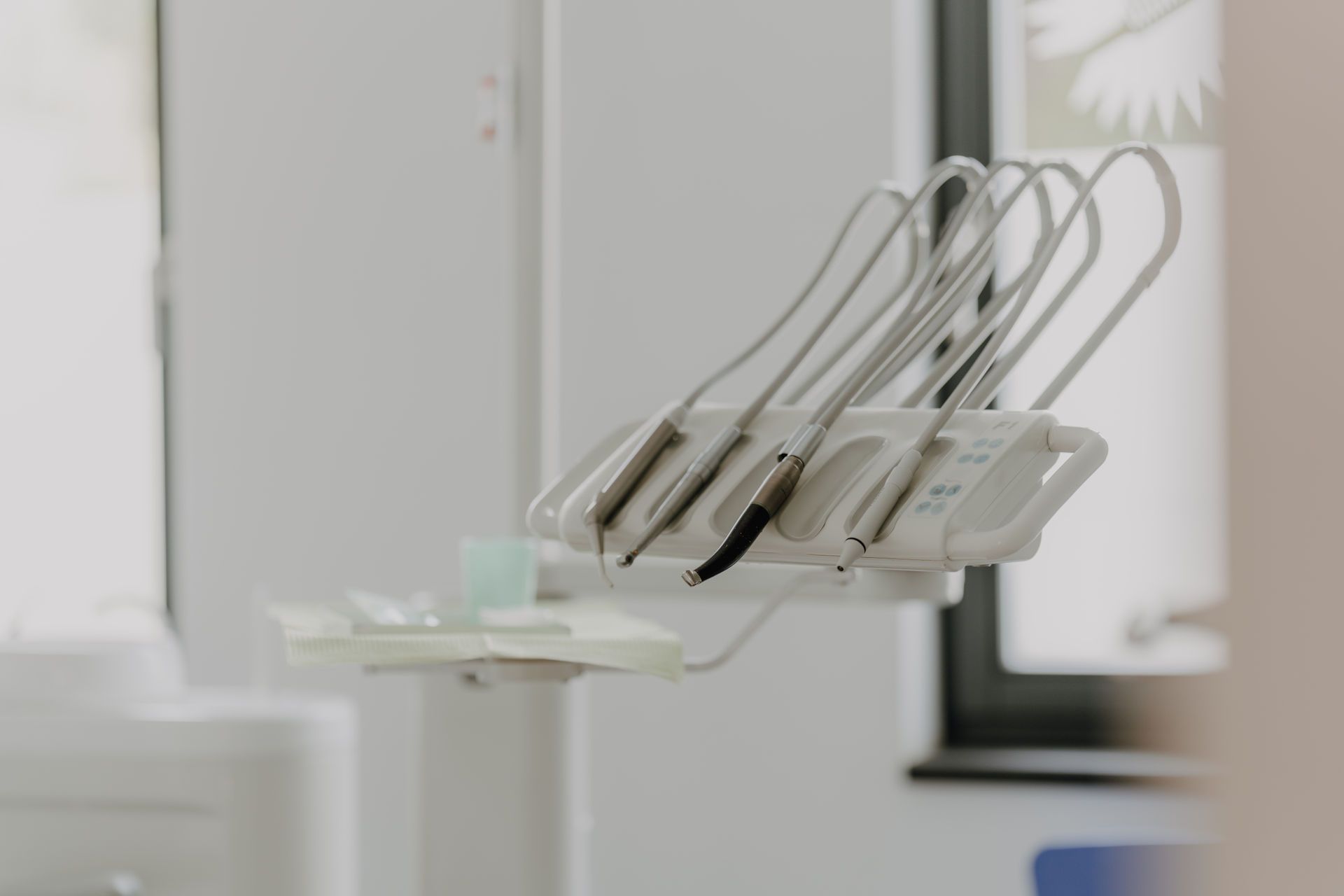 Zwei Personen in blauer OP-Kleidung lehnen lächelnd an einer blauen Säule im Flur einer Arztpraxis.