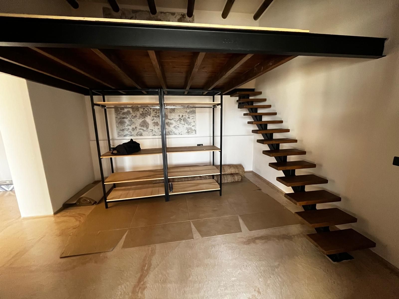 Una habitación con una escalera y estantes en ella.