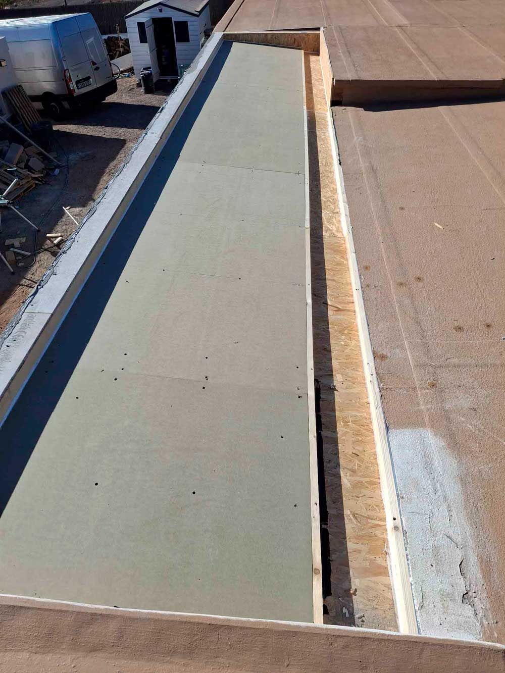 Un gran trozo de madera está colocado encima de un tejado.