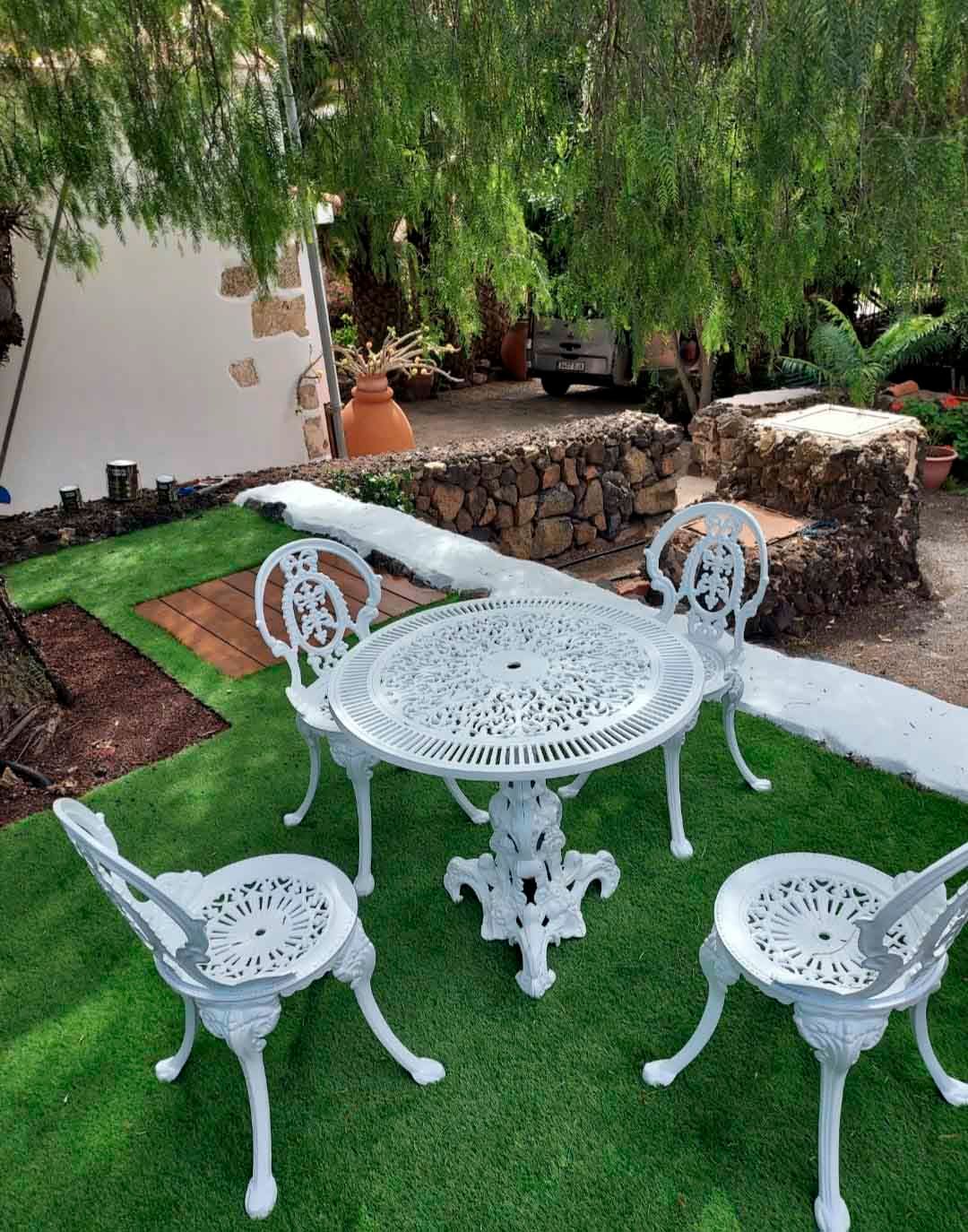 Una mesa y sillas están colocadas sobre un exuberante césped verde.